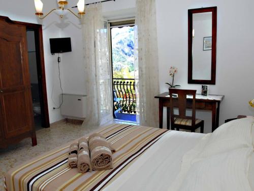 um quarto com uma cama com sandálias e uma varanda em B&B Reale em Tramonti