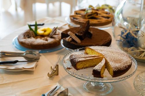 stół z wieloma różnymi rodzajami ciast na nim w obiekcie Hotel Gran Torre w mieście Cabras