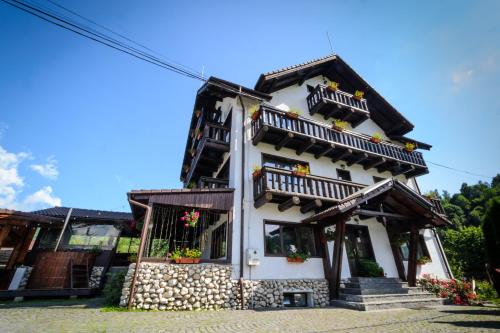 un edificio blanco con balcones y flores. en Bradutul de la Munte, en Bran