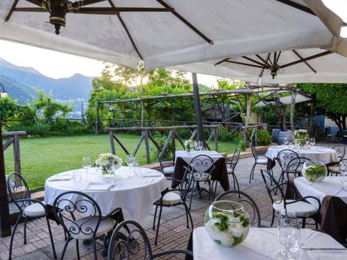 a group of tables and chairs under a white umbrella at B&B Reale in Tramonti