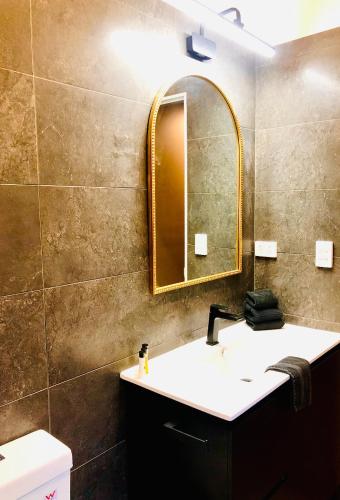a bathroom with a sink and a mirror and a toilet at Noosa Hinterland Retreat in Tinbeerwah