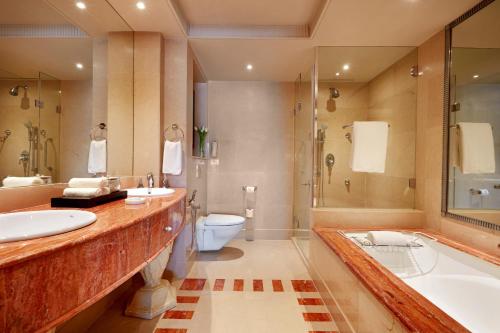 a bathroom with two sinks and a tub and a toilet at ITC Maratha, a Luxury Collection Hotel, Mumbai in Mumbai