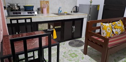 a kitchen with a counter and a chair and a sink at ABODE21 Guesthouse in Balingasay