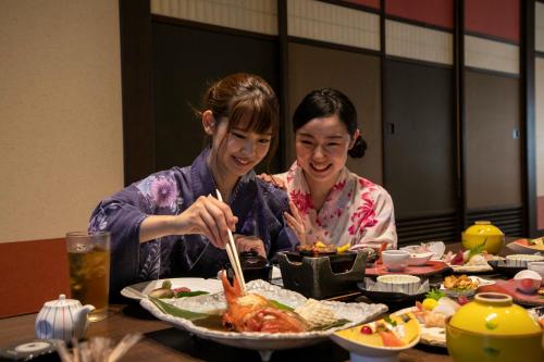 two women sitting at a table eating food at Yuyado Ichibanchi in Atami