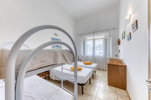 a bedroom with two bunk beds and a window at Villetta Relax in Castrignano del Capo