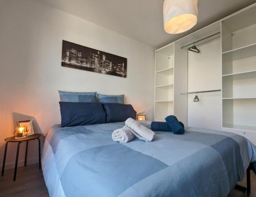 une chambre avec un lit bleu avec des serviettes dessus dans l'établissement La Terrasse du 7ème Art, à Bezons