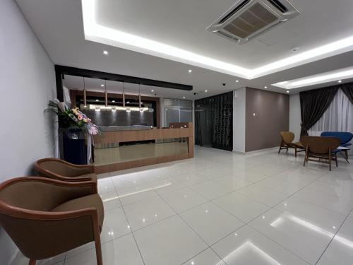 a lobby with chairs and a reception desk in a building at GRAND AROMAS in Kulai