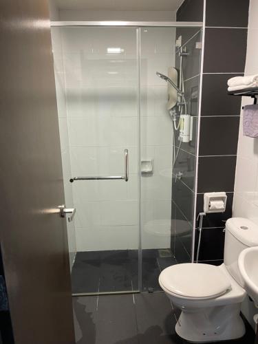 a bathroom with a shower with a toilet and a sink at One Majestic Ipoh - 3 Bedroom Apt For Family of 5 in Ipoh