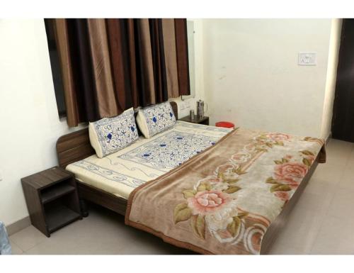 un letto con lenzuola e cuscini blu e bianchi di Hotel Gopi Dham, Haridwar a Haridwār
