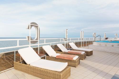 a balcony with chairs and a swimming pool on a cruise ship at Hotel Acapulco in Milano Marittima