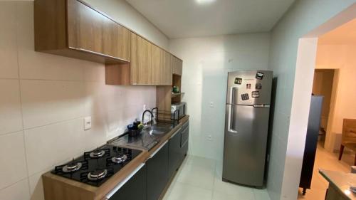 a kitchen with a stainless steel refrigerator and cabinets at Quarto Suíte em apto compartilhado com anfitrião Mandi a 250m do Mar in Itapema