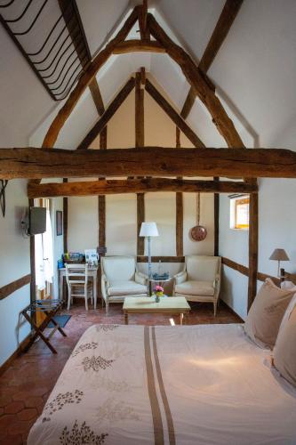 une chambre avec un lit et un salon dans l'établissement L'Etape Normande, à Montroty