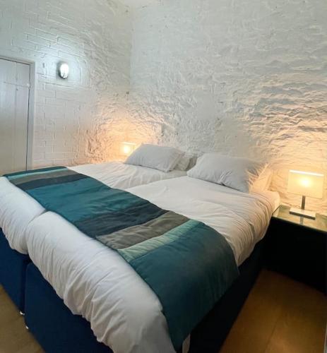 un grande letto in una stanza con due lampade di The Garden Flat a Plymouth