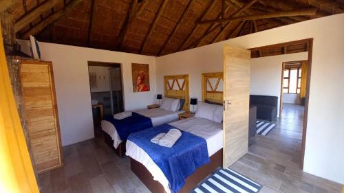 a bedroom with two beds in a room with wooden ceilings at FLY FISHING PARADISE ON THE VAAL in Parys