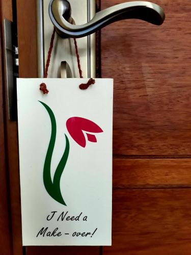 a sign on a door with a flower on it at Pink Tulip Hoi An in Hoi An