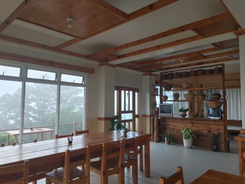 a dining room with a large wooden table and chairs at Cam-Jhao's Homestay in Sagada