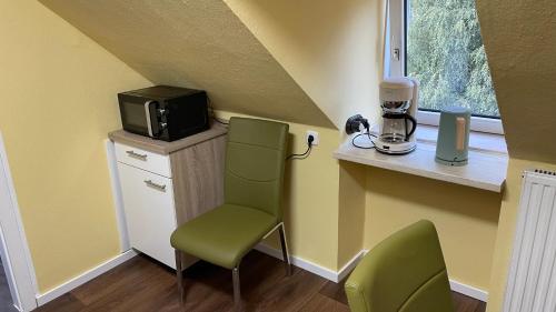 um pequeno quarto com um micro-ondas, uma cadeira e um micro-ondas em DG Apartament em Bersenbrück