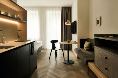 een keuken en een woonkamer met een tafel en een bank bij Melter Hotel & Apartments - a Neighborhood Hotel in Neurenberg