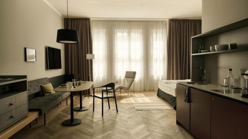 ニュルンベルクにあるMelter Hotel & Apartments - a Neighborhood Hotelのベッド、テーブル、椅子が備わるホテルルームです。