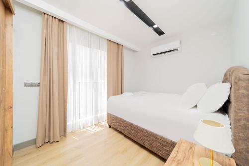 a bedroom with a bed and a large window at Modern Flat w Balcony 10 min to Beach in Antalya in Antalya