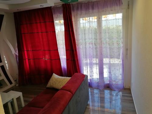 un soggiorno con divano rosso di fronte a una finestra di Luxury Voll möblierte 2 Zimmer Appartement Aarau a Küttigen