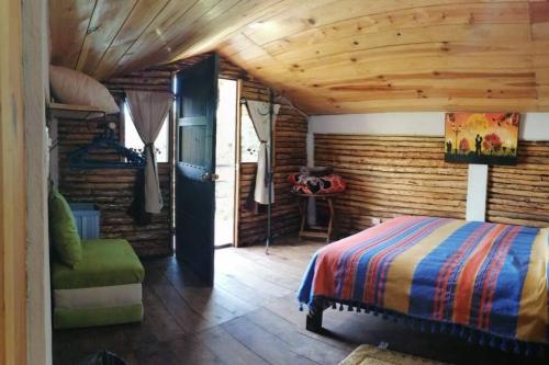 聖克里斯托瓦爾－德拉斯卡薩斯的住宿－LIN K'AK' Cabaña San Cristobal de las casas，一间卧室设有一张床和木墙