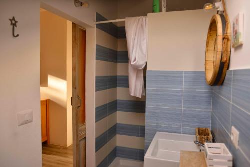 uma casa de banho com um lavatório branco e azulejos azuis em PM Villa Tania Guest House em Alghero