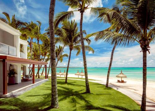 um resort com palmeiras na praia em One&Only Le Saint Géran, Mauritius em Belle Mare