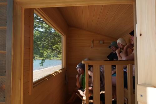 a group of people sitting in a sauna at Roots inawashiro Lake Area in Sekiwaki