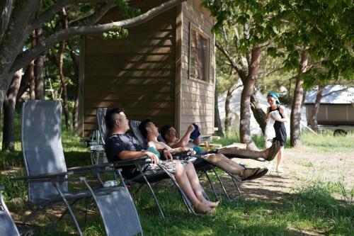 a group of people sitting in chairs in the grass at Roots inawashiro Lake Area in Sekiwaki