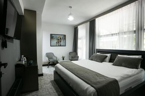 a bedroom with a large bed and a large window at Monk House in Yerevan