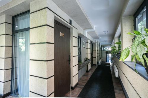 a hallway of a building with a door and plants at Monk House in Yerevan