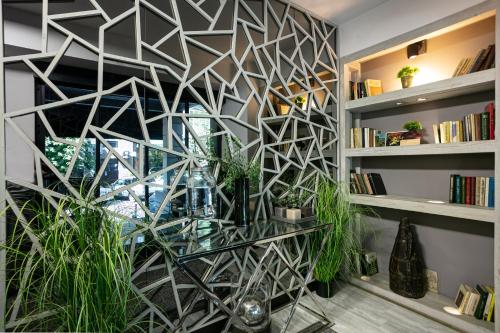 a feature wall with a geometric design in a room with plants at Monk House in Yerevan