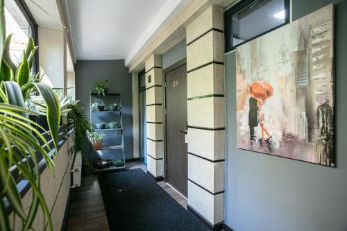 a hallway with a large painting of a woman with an umbrella at Monk House in Yerevan