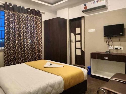 a bedroom with a bed and a desk and a tv at KJR Residency&Rooms in Chennai