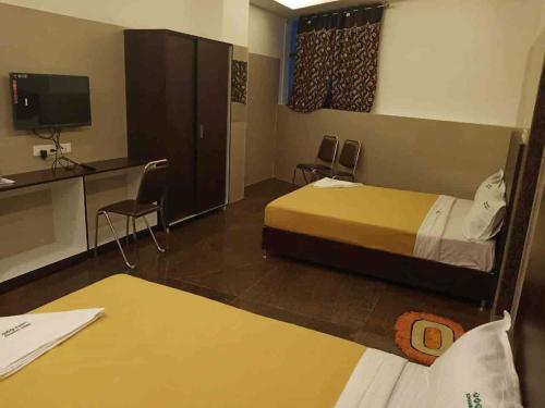 a hotel room with a bed and a desk and a tv at KJR Residency&Rooms in Chennai