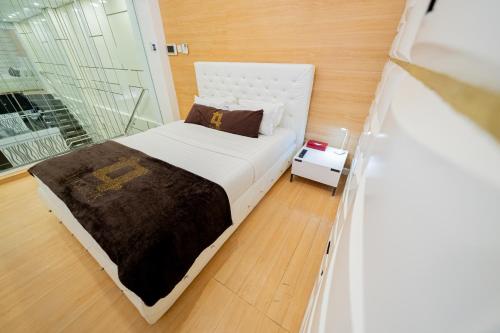 a small bedroom with a bed and a window at Luks Lofts Hotel & Residences in Batangas City