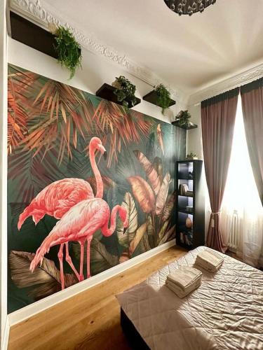 a bedroom with a mural of flamingos on the wall at Bay of Art in Trieste