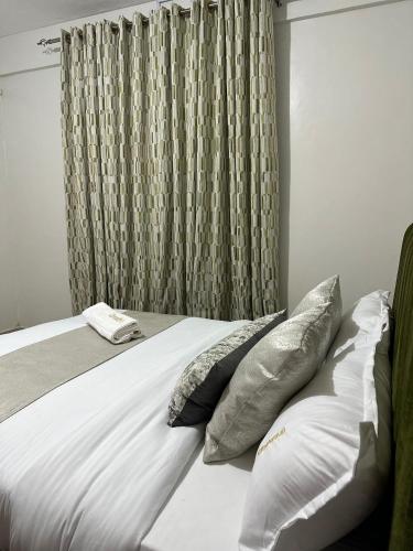 una camera da letto con letto con cuscini e tenda di Cloud9 bnb kericho Annex a Kericho