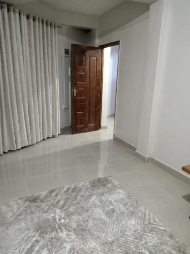 una sala de estar vacía con una puerta y una alfombra en Cloud9 bnb kericho Annex, en Kericho