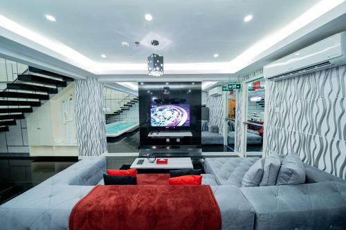 a living room with a large couch and a tv at Luks Lofts Hotel & Residences in Batangas City