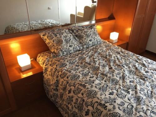 a bedroom with a bed with two lamps on it at Apartamento Playa de Usil in Mogro