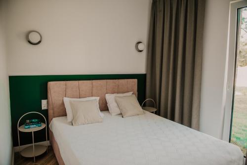 una camera da letto con un grande letto con una parete verde di Sam Las Apartamenty Białowieża a Białowieża