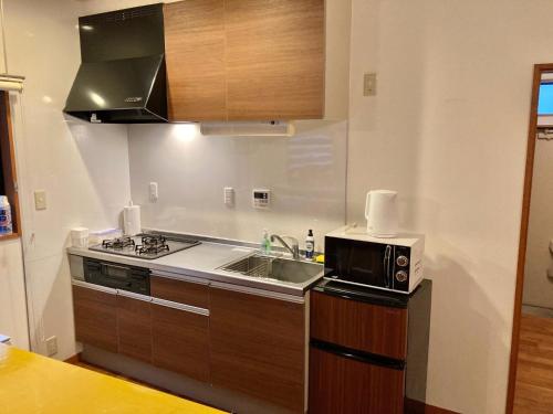 a kitchen with a sink and a microwave at ＡＴＴＡ ＨＯＴＥＬ ＫＡＭＡＫＵＲＡ / Vacation STAY 76829 in Kamakura