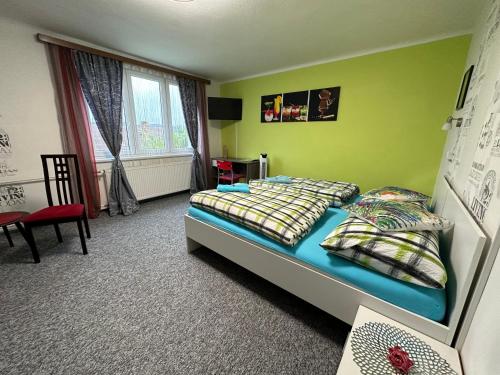 ein Schlafzimmer mit einem Bett und einer grünen Wand in der Unterkunft Apartmány MK u MODRÉ KOČKY in Nové Hrady