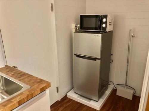 a small kitchen with a microwave on top of a refrigerator at ＡＴＴＡ ＨＯＴＥＬ ＫＡＭＡＫＵＲＡ - Vacation STAY 16380v in Kamakura