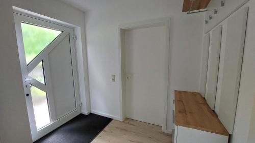 um quarto vazio com uma porta e uma janela em Appartement, komplett saniert, 47 m², mit Terrasse und Gartennutzung em Meinerzhagen