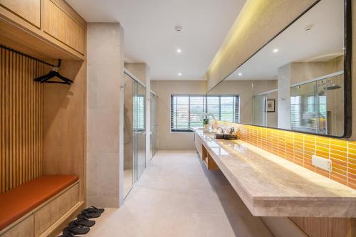La salle de bains est pourvue d'un long comptoir avec du carrelage jaune. dans l'établissement Locanda Villanova Bed & Breakfast, à Pak Chong
