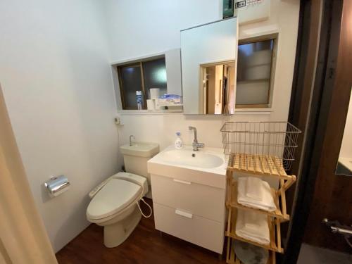 bagno con servizi igienici, lavandino e specchio di ＡＴＴＡ ＨＯＴＥＬ ＫＡＭＡＫＵＲＡ / Vacation STAY 77545 a Kamakura