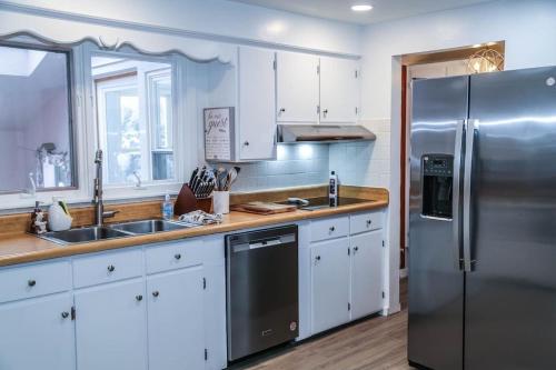 a kitchen with white cabinets and a stainless steel refrigerator at Sunset house near Sunday River Black Montain in Rumford